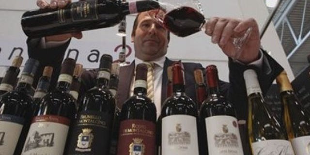 A man pours a glass of Tuscany red wine during the 46th edition of the annual International Wine and Spirits Exhibition "Vinitaly", in Verona, northern Italy, Monday, March 26, 2012. The wine exhibition runs until March 28. (AP Photo/Luca Bruno)