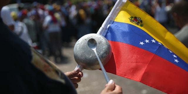 SAN CRISTOBAL, VENEZUELA - MARCH 08: Anti-government protesters bang pots and pans while marching on March 8, 2014 in San Cristobal, the capital of Tachira state, Venezuela. Shortage of such products as flour, milk and sugar have made life increasingly difficult for residents of Tachira, which has been a focal point for anti-government protests for almost a month. (Photo by John Moore/Getty Images)