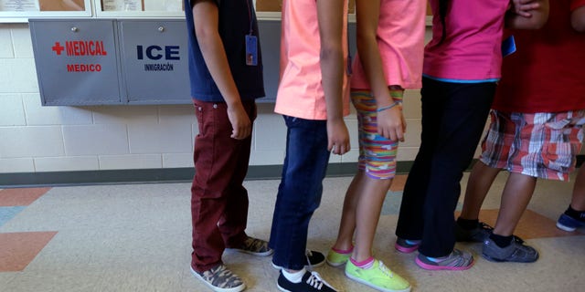 FILE - In this Sept. 10, 2014 file photo, detained immigrant children line up in the cafeteria at the Karnes County Residential Center, a temporary home for immigrant women and children detained at the border, in Karnes City, Texas. Homeland Security Secretary Jeh Johnson says federal officials are making "substantial changes" to end the long-term detention of migrant families who are being held mainly at two large facilities in Texas. (AP Photo/Eric Gay, File)