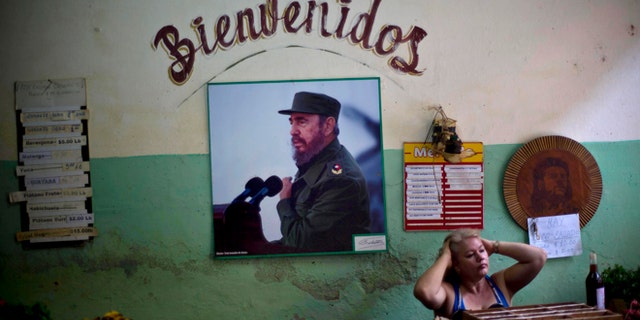 FILE - In this Dec. 26, 2014 file photo, a photograph of Fidel Castro hangs under the Spanish word "Welcome" on the wall at a state-run food market in Havana, Cuba. On Monday, Jan. 26, 2015, after more than a month of silence, Castro made his first public comments about the news that the U.S. and his island nation will restore diplomatic relations after more than 50 years of hostility. (AP Photo/Ramon Espinosa, File)