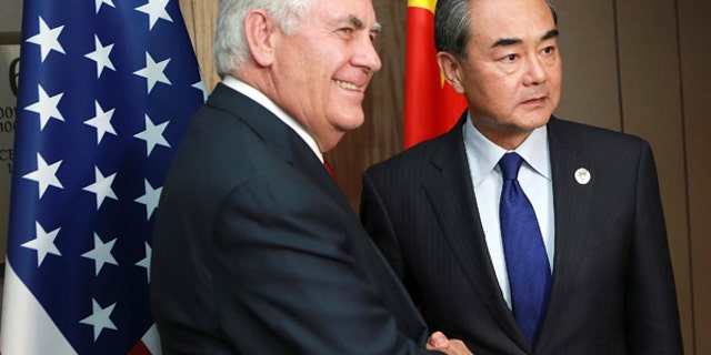 Chinese Foreign Minister Wang Yi , right, and US Secretary of State Rex Tillerson pose for a photograph during their bilateral meeting on the sidelines of the 50th Association of Southeast Asian Nations (ASEAN) Regional Forum (ARF) in Pasay City southeast of Manila, Philippines, Sunday, Aug. 6, 2017. (Rouelle Umali/Pool Photo via AP)