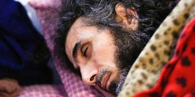 FILE - In this Sept. 9, 2016 file photo, Syrian native Abu Wa'el Dhiab rests in bed while conversing with his family via a laptop, in his apartment in Montevideo, Uruguay. An Uruguayan official said on Sept. 14 that the health of the resettled former Guantanamo detainee has taken a turn for the worse due to a hunger strike he launched to demand relocation to another country. He says he no longer wants to remain in Uruguay and would like to join his wife and daughters in Turkey. Uruguayan officials say they are trying to find another country to accept him. (AP Photo/Matilde Campodonico, File)