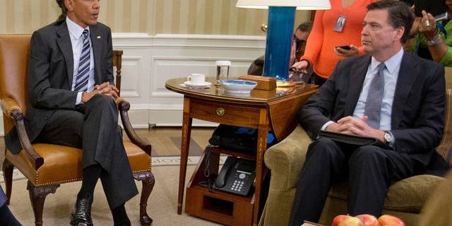 FBI Director James Comey, right, listens to President Barack Obama, left, speak to members of the media in the Oval Office of the White House in Washington, Monday, June 13, 2016, after receiving an update on the massacre at an Orlando nightclub. Comey says the gunman in the Orlando nightclub attack that killed 49 people had "strong indications of radicalization" and was likely inspired by foreign terrorist organizations. (AP Photo/Pablo Martinez Monsivais)