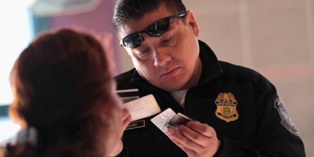 NOGALES, AZ - DECEMBER 10: Officer Juan Osorio inspects the identifications of a Mexican citizen at the U.S.-Mexico border crossing on December 10, 2010 in Nogales, Arizona. Despite Arizona's tough immigration enforcement laws, thousands of Mexican citizens have permits to work in the U.S. and commute daily from their homes across the border in Mexico. Border crossings, known as "ports of entry," are run by the U.S. Office of Field Operations, which is part of the department of U.S. Customs and Border Protection. Port personnel are the face at the border for most visitors and cargo entering the United States and are authorized to stop, question, search and examine everyone entering the country. (Photo by John Moore/Getty Images)