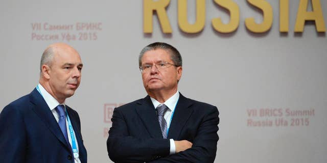 FILE - In this file photo taken on Thursday, July 9, 2015, Anton Siluanov, left, Minister of Finance of the Russian Federation, and Alexey Ulyukayev, Minister of Economic Development of the Russian Federation speak in Ufa, Russia. A long-serving Russian minister has been detained over an alleged $2 million bribe, the most senior government official to face corruption charges in a quarter-century. (Government Pool Photo via AP, File)