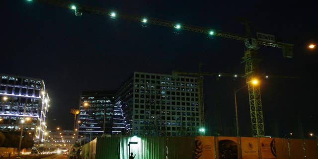 A Filipino worker checks his phone as he waits outside a construction site at a commercial area in suburban Pasay, south of Manila, Philippines, Thursday, May 19, 2016. The Philippine economy grew faster than expected at 6.9 percent in the first quarter from the same period a year ago, its highest quarterly growth in almost three years, officials said Thursday as the government prepares to hand over leadership to the incoming administration. (AP Photo/Aaron Favila)
