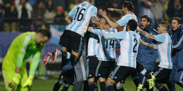 Argentina's players jump over Carlos Tevez after scored the winning penalty kick against Colombia during a Copa America quarterfinal soccer match at the Sausalito Stadium in Vina del Mar, Chile, Friday, June 26, 2015. (AP Photo/Ricardo Mazalan)