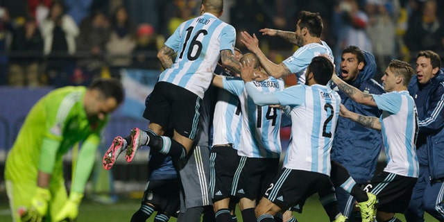 Argentina's players jump over Carlos Tevez after scored the winning penalty kick against Colombia during a Copa America quarterfinal soccer match at the Sausalito Stadium in Vina del Mar, Chile, Friday, June 26, 2015. (AP Photo/Ricardo Mazalan)
