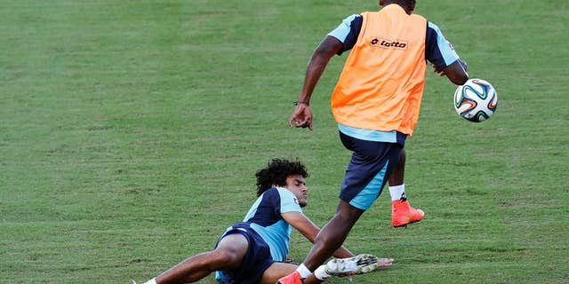 Costa Rica's Yeltsin Tejeda falls as he is tackled during a training session in Salvador, Brazil, Friday, July 4, 2014. Costa Rica play their quarterfinal match of the 2014 World Cup soccer tournament against Netherlands on July 5 in Salvador(AP Photo/Wong Maye-E)