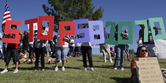 Demonstrators protest against Arizona's immigration law before marching to the State Capitol in Phoenix May 29. (Reuters Photo)