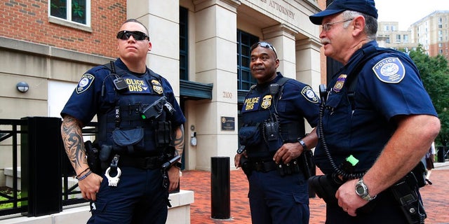 Security personnel from the Department of Homeland Security's Federal Protective Service, watch the vicinity around the Alexandria Federal Court in Alexandria, Va., on day one of Paul Manafort's trial, Tuesday, July 31, 2018.