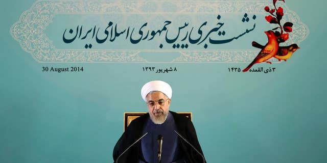 Iranian President Hassan Rouhani gives a press conference in Tehran, Iran, Saturday, Aug. 30, 2014. Rouhani called Western sanctions an "invasion" on Saturday after Washington imposed existing sanctions on more than 25 businesses, banks and individuals suspected of working to expand Iran's nuclear program, support terrorism and help Iran evade U.S. and international sanctions. Iran's state TV also said the move violated an interim agreement reached with world powers under which Western nations agreed to ease sanctions in exchange for Iran curbing its nuclear activities. However, Friday's action did not constitute an expansion of the sanctions regime. (AP Photo/Ebrahim Noroozi)