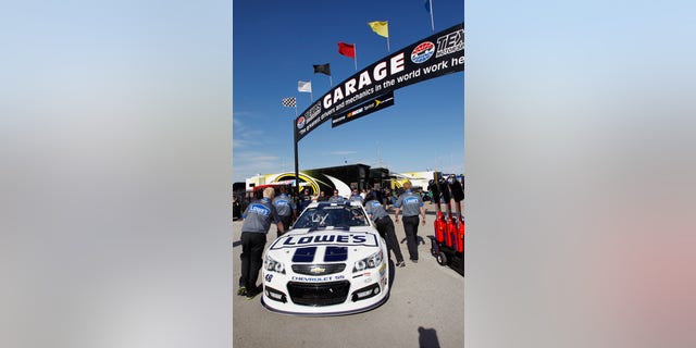 Jimmie Johnson's car is pushed to the garage before the NASCAR Sprint Cup series NRA 500 auto race at Texas Motor Speedway, Saturday, April 13, 2013, in Fort Worth, Texas. (AP Photo/Tim Sharp)