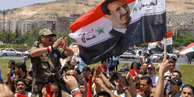 June 20: Pro-Syrian regime protesters shout President Bashar Assad slogans after he delivered a speech, in Damascus, Syria.