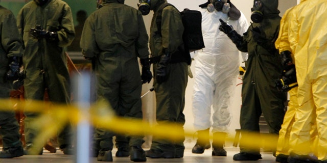 Hazmat crews are gathered at the main hall of Kuala Lumpur International Airport 2 in Sepang, Malaysia on Sunday, Feb. 26, 2017. Malaysian police ordered a sweep of Kuala Lumpur airport for toxic chemicals and other hazardous substances following the killing of Kim Jong Nam. (AP Photo/Daniel Chan)