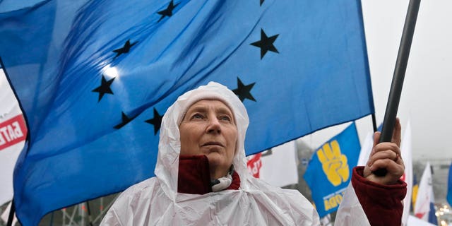 An activist holds a European Union flag during a rally at European Square in Kiev, Ukraine, Monday, Nov. 25, 2013. Demonstators rallied in the center of Kiev to demand that the Ukrainian government reverse course and sign a landmark agreement with the European Union in defiance of Russia. (AP Photo/Efrem Lukatsky)