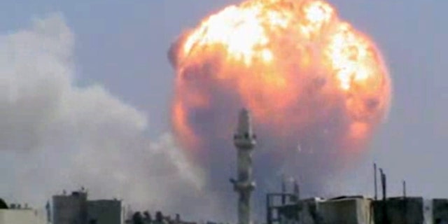 FILE - This Monday, July 15, 2013, file image taken from leaked video obtained by Ugarit News, which has been authenticated based on its contents and other AP reporting, purports to show a fireball from an explosion at a weapons depot set off by rocket attacks that struck government-held districts in the central Syrian city of Homs. Never in history has a war been covered in the way that Syria’s civil war has: A constant stream of hundreds of thousands of videos instantaneously bringing all the viciousness, brutality and gore instantaneously and vividly to millions of viewers across the globe via YouTube and social media. The raw footage from Syria's battlefields comes in a perpetual stream _ a vicious civil war brought instantaneously to millions of viewers across the globe via YouTube and social media.(AP Photo/Ugarit News via AP video)