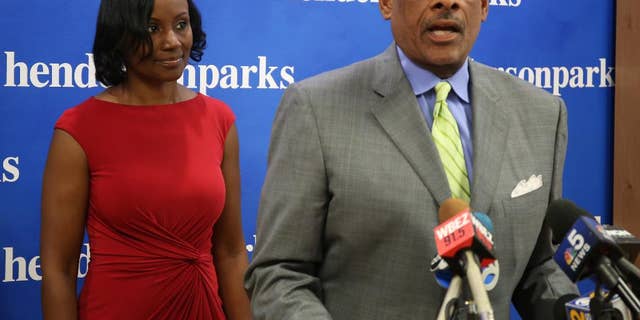 Rhonda Crawford,left, a court staff attorney fired after donning a robe and hearing real cases on the bench, listens to her lawyer Victor Henderson at a news conference in Chicago on Thursday, Sept.22, 2016. Crawford says she regrets overseeing several traffic cases. But she says the actual judge, Valarie E. Turner, stood over her the whole time and issued all rulings. Crawford was fired over the incident and Turner was removed from the bench indefinitely. (Phil Velasquez/Chicago Tribune via AP)