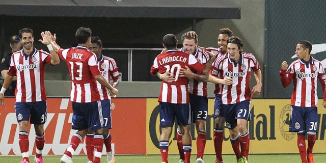 FILE - This July 28, 2012, file photo shows Chivas USA's Danny Califf (23) embraces teammate Nick LaBrocca (10) after he scores in the second half during an MLS soccer game with the Portland Timbers in Portland, Ore. Chivas USA ceased operations on Monday, Oct. 27, 2014, after 10 troubled and unsuccessful years in Major League Soccer, with the league planning a new franchise for Los Angeles that will begin play in 2017 with new ownership and a new soccer-specific stadium. (AP Photo/Rick Bowmer, File)