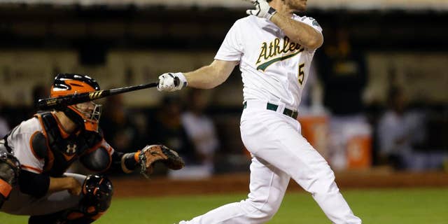 Oakland Athletics' John Jaso swings for an RBI ground out against the San Francisco Giants in the fifth inning of a baseball game Monday, July 7, 2014, in Oakland, Calif. (AP Photo/Ben Margot)