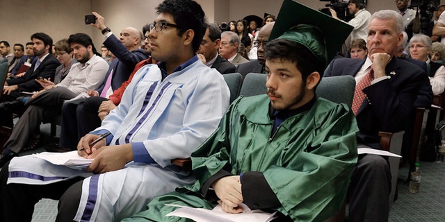 Erick Dominquez, of Houston, left, and Jesus Trevino sit in the front row of hearing committee room waiting to testify against a repeal of the so-called "Texas Dream Act" of 2001, in Austin, Texas, Monday, April 6, 2015. The Republican-controlled Legislature began a push Monday to repeal Texas' 14-year-old law that gives the children of some people living in the United States illegally in-state tuition at public universities.(AP Photo/Austin American-Statesman, Rodolfo Gonzalez) AUSTIN CHRONICLE OUT, COMMUNITY IMPACT OUT, INTERNET AND TV MUST CREDIT PHOTOGRAPHER AND STATESMAN.COM, MAGS OUT