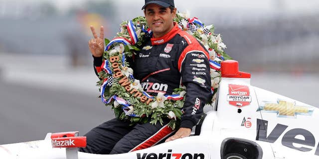Juan Pablo Montoya, of Colombia, poses in his car during the traditional winners photo session at Indianapolis Motor Speedway in Indianapolis, Monday, May 25, 2015. Montoya won the 99th running of the Indianapolis 500 auto race on Sunday. (AP Photo/Michael Conroy)