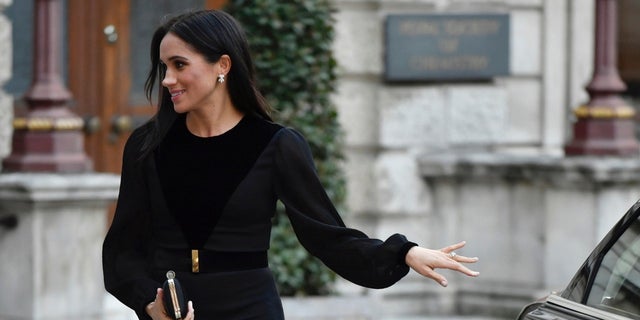 Meghan Markle closes her own car door while at her first royal solo outing.