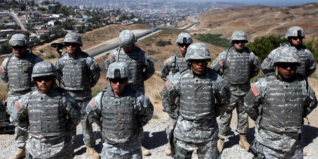 SAN YSIDRO, CA - AUGUST 18: National Guardsmen stand in formation along the U.S.-Mexico border during a visit by California Gov. Arnold Schwarzenegger August 18, 2010 in San Ysidro, California. U.S. President Barack Obama has ordered more than a thousand National Guard troops to the border in response to border patrol agents who are overwhelmed by drug smugglers and illegal immigrants. (Photo by Sandy Huffaker/Getty Images)