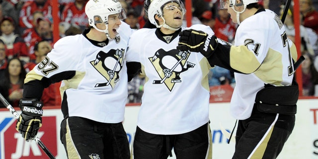 Pittsburgh Penguins left wing Chris Kunitz, center, celebrates his goal with teammate Sidney Crosby (87) and Evgeni Malkin (71), of Russia, during the second period of an NHL hockey game on Sunday, Feb. 3, 2013, in Washington. (AP Photo/Nick Wass)