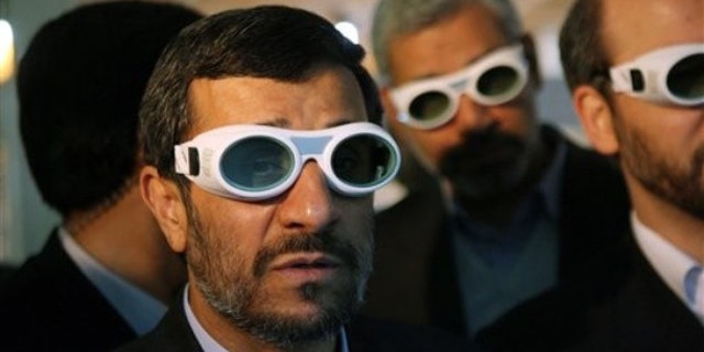 File: Iranian President Mahmoud Ahmadinejad, wears eye protection goggles as he visits an exhibition of Iran's laser science in Tehran.