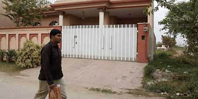 Dec. 10: A man walks past a house which residents say was raided by Pakistani security forces during the arrest of five Americans.