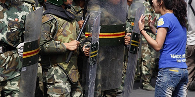 July 7: An Uighur woman protests before a group of paramilitary police in Urumqi, China.