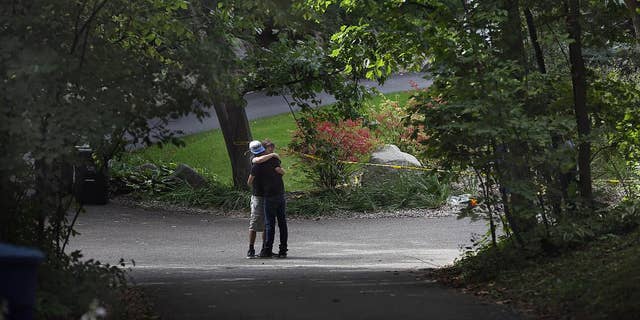 Nick Collins, right, embraces Minnetonka High School classmate Nathan Kahn during a visit Friday, Sept. 11, 2015, to the scene where five family members were found inside a home in Greenwood, Minn. Police pushed ahead Friday with their investigation into an apparent murder-suicide in the affluent Minneapolis suburb that left a family of five dead, while a high school offered counseling to classmates of the three children. (Jim Gehrz/Star Tribune via AP) MANDATORY CREDIT; ST. PAUL PIONEER PRESS OUT; MAGAZINES OUT; TWIN CITIES LOCAL TELEVISION OUT