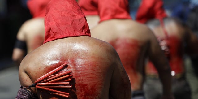 Filipino hooded penitents flagellate themselves during Maundy Thursday rituals to atone for sins on March 28, 2013, in suburban Mandaluyong, east of Manila, Philippines. The ritual is frowned upon by church leaders in this predominantly Roman Catholic country. (AP Photo/Aaron Favila)
