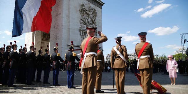 Britain's Queen Elizabeth is accompanied by France's President Francois Hollande as she attends a wreath-laying ceremony at the Arc de Triomphe in Paris, France, Thursday, June 5, 2014. The Queen arrived in Paris to start a three-day state visit and participate in ceremonies commemorating the D-day landings in Normandy. (AP Photo/Charles Platiau,pool)