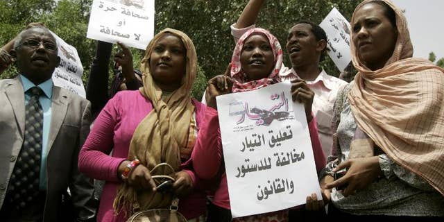 Sudanese journalists hold slogans which read in Arabic "Press freedom or no press" and " Suspension of Al-Tayyar daily is against the constitution and law" in Khartoum on July 17, 2012