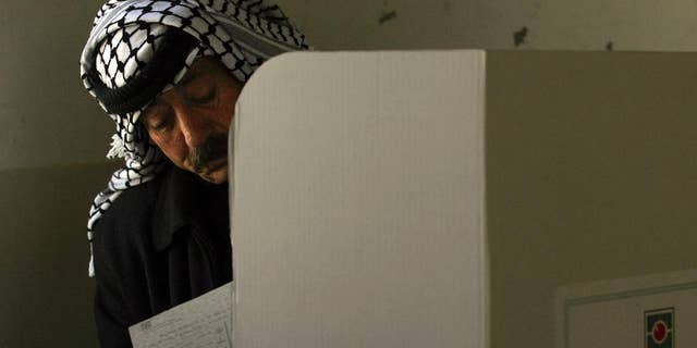 FILE - In this Jan. 22, 2006 file photo, a Palestinian police officer fills in his ballot before casting it in parliamentary elections in the West Bank city of Nablus. The Palestinian high court on Monday, Oct. 3, 2016 ruled upcoming municipal elections will be held in the West Bank only, excluding the Hamas-controlled Gaza Strip, in a move that suspends the first political contest in a decade between the rival Fatah and Hamas in both territories. (AP Photo/Emilio Morenatti, File)