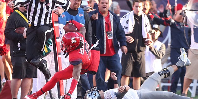 University of Arizona cornerback Shaquille Richardson (5) is knocked out of bounds by Oregon quarterback Marcus Mariota (8) after he picked off Mariota's pass during the fourth quarter at Arizona Stadium in Tucson on Nov. 23, 2013. Arizona upset Oregon. (AP Photo/Arizona Daily Star, Mike Christy)