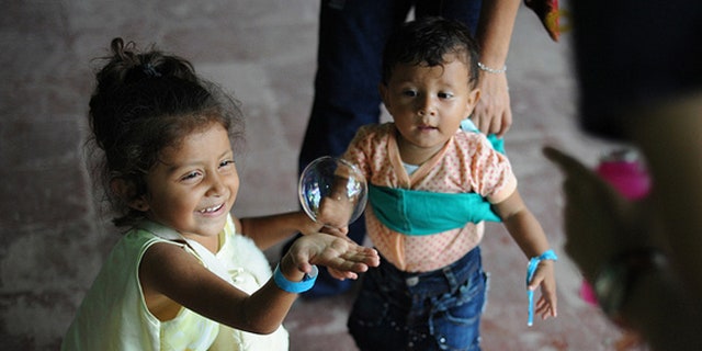 Children chase bubbles outside the family medicine exam room during a Continuing Promise 2011 medical community service event Las Morenas medical site in Puerto San José, Guatemala. (U.S. Navy photo by Mass Communication Specialist 2nd Class Eric C. Tretter/Released)