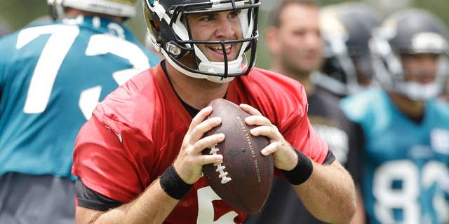 FILE - In this June 18, 2014, file photo, Jacksonville Jaguars quarterback Blake Bortles (5) looks for a receiver during a team scrimmage at NFL football minicamp in Jacksonville, Fla. The majority of teams pay their starting quarterbacks just a fraction of the base salaries of the Peyton Mannings, Tom Brady and Jay Cutler, who makes $17.5 million this season.(AP Photo/John Raoux, File)