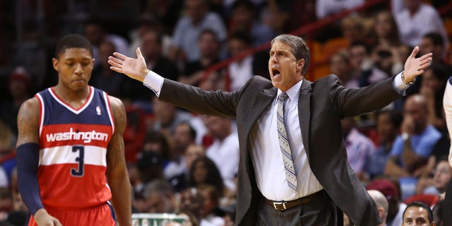 Washington Wizards coach Randy Wittman protests a penalty call against the team, after they fouled a Miami Heat player during the first half of an NBA basketball game in Miami, Sunday, Nov. 3, 2013. Bradley Beal walks past. (AP Photo/J Pat Carter)