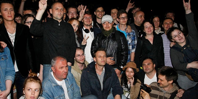May 8, 2012: Alexei Navalny, at bottom center, a prominent anti-corruption whistle blower and blogger, and opposition leader Sergei Udaltsov, standing at second from left, pose with protesters gathering in the opposite side of the Presidential administrations building in downtown Moscow early Tuesday, a day after Vladimir Putin's inauguration.