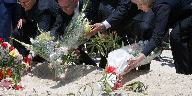 From right to left British Home Secretary Theresa May, Tunisian Interior Minister Mohamed Najem Gharsalli, , German Interior Minister Thomas de Maiziere and French Interior Minister Bernard Cazeneuve  lay flowers on the beach in front of the Imperial Marhaba hotel in the Mediterranean resort of Sousse for the tribute in Sousse, Tunisa, Monday, June 29, 2015. The top security officials of Britain, France, Germany and Belgium are paid homage to the  people killed in the terrorist attack in Sousse on Friday.  (AP Photo/Abdeljalil Bounhar)