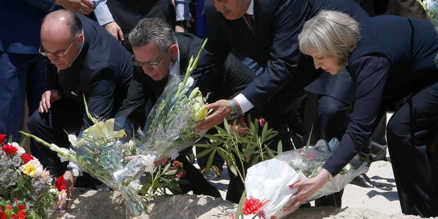 From right to left British Home Secretary Theresa May, Tunisian Interior Minister Mohamed Najem Gharsalli, , German Interior Minister Thomas de Maiziere and French Interior Minister Bernard Cazeneuve lay flowers on the beach in front of the Imperial Marhaba hotel in the Mediterranean resort of Sousse for the tribute in Sousse, Tunisa, Monday, June 29, 2015. The top security officials of Britain, France, Germany and Belgium are paid homage to the people killed in the terrorist attack in Sousse on Friday. (AP Photo/Abdeljalil Bounhar)