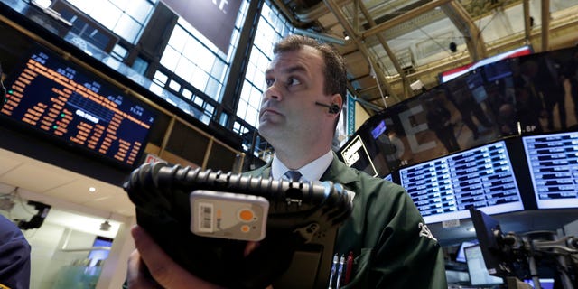 In this Tuesday, Feb. 26, 2013, photo,  Trader William Lawrence works on the floor of the New York Stock Exchange.Futures are rising as Chairman Ben Bernanke heads to Capitol Hill to explain what the Federal Reserve will do to accelerate the economic recovery.  (AP Photo/Richard Drew)