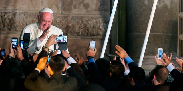 Faithful take picture with their mobile phones as Pope Francis departs from the San Francisco Church aboard the Popemobile, in Quito, Ecuador, Tuesday, July 7, 2015. The Pontiff met with representatives of civic organizations, entrepreneurs, indigenous communities and Catholic lay groups. (AP Photo/Fernando Llano)