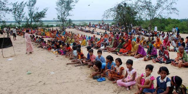 Villagers sit along the entry point to prevent policemen and officials from entering their land in Jagatsinghpur district, about 140 kilometres east of the eastern Indian city of Bhubaneswar, on June 18, 2011