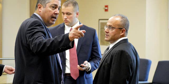 Defense attorneys Sam Bregman, left and Luis Robles, right, discuss their clients case on Friday, July 31, 2015, in Albuquerque, N.M. A former Albuquerque detective and a current officer are facing murder charges in the March 2014 fatal police shooting of a homeless man. A state judge ruled Friday that a jury can be told limited information about the homeless man's prior arrest. (AP Photo/Russell Contreras)