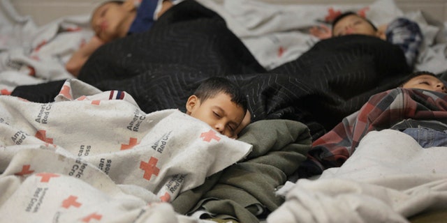 June 18, 2014: Children detainees sleep in a holding cell at a U.S. Customs and Border Protection processing facility in Brownsville, Texas. (AP)