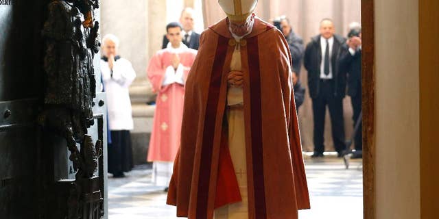 Pope Francis stands after opening the Holy Door of St. John in Lateran Basilica in Rome, Sunday, Dec. 13, 2015. (Stefano Rellandini/Pool Photo via AP)
